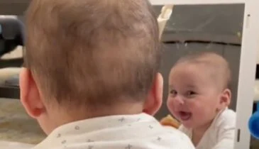 Deze baby krijgt de slappe lach als hij zich zelf ziet!